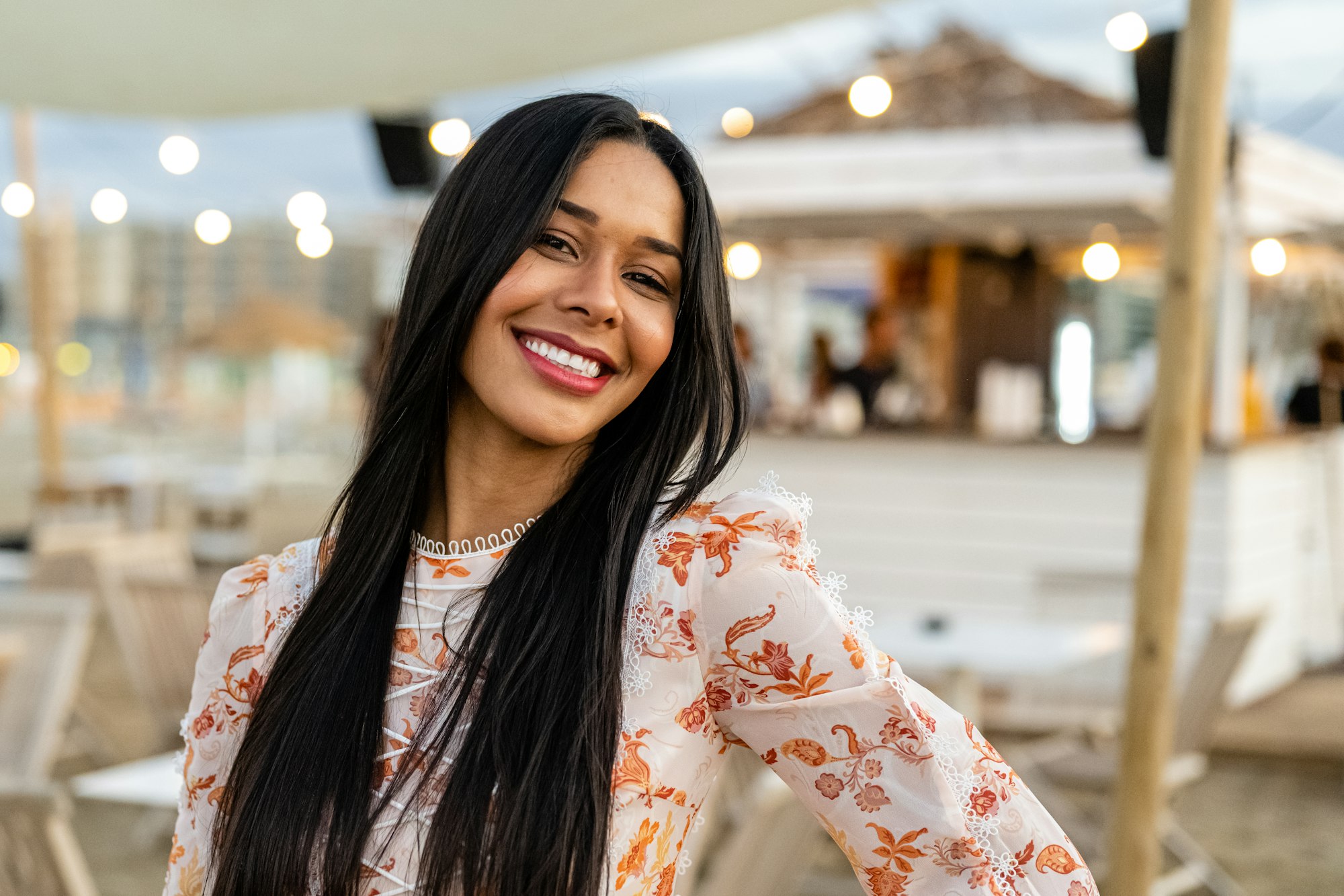 Beautiful and smiling Brazilian woman looking at the camera, luxury holiday concept in resort