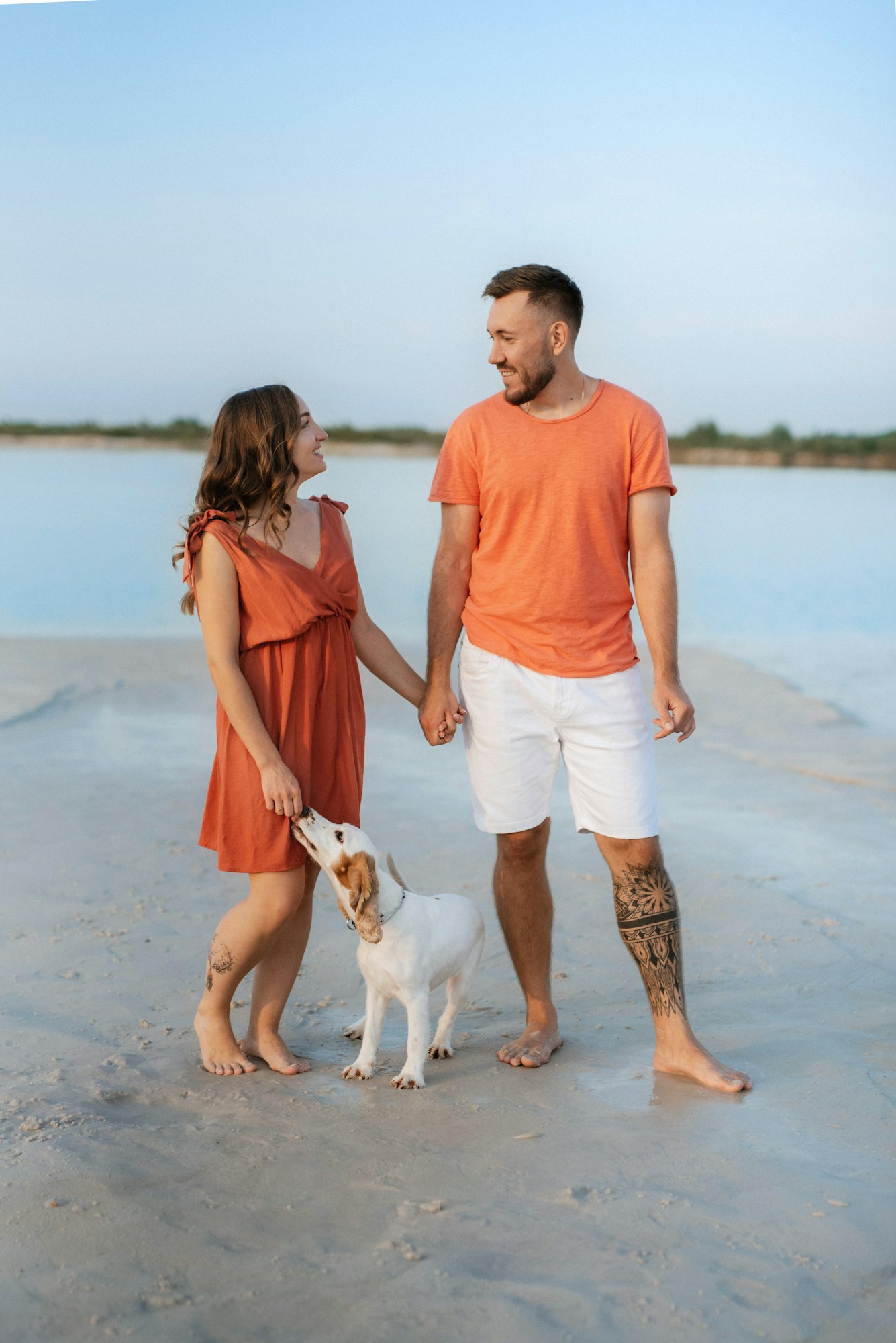 young couple in orange clothes with dog